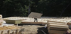 A carpenter carries plywood flooring at a building site of Mid-Atlantic Builders' 'The Villages of Savannah' in Brandywine